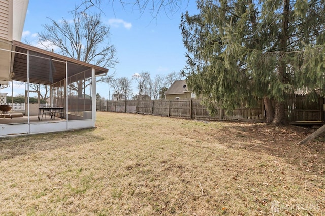 view of yard with a fenced backyard and a sunroom