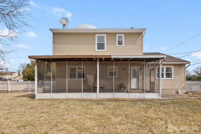 back of property featuring a sunroom, fence, and a lawn