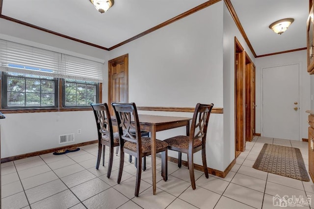 dining room with ornamental molding and light tile patterned floors