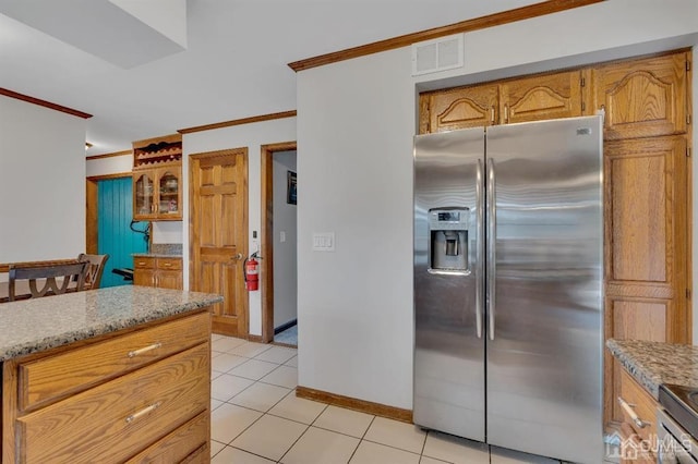 kitchen featuring light tile patterned flooring, light stone countertops, ornamental molding, and stainless steel fridge with ice dispenser