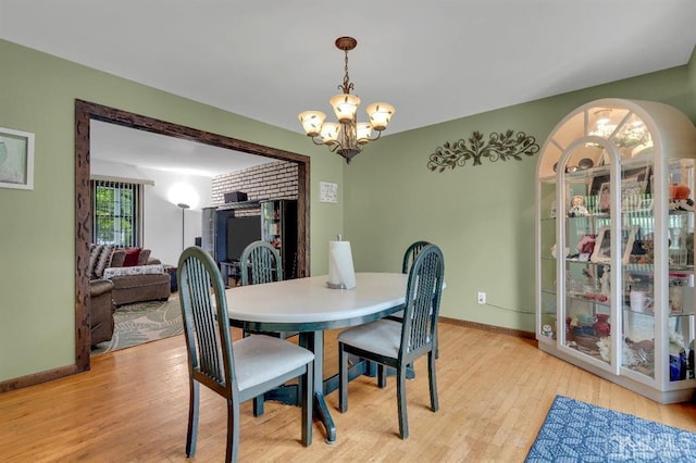 dining space with a notable chandelier and light wood-type flooring