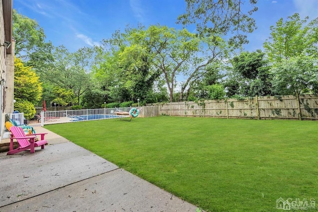 view of yard featuring a patio area and a fenced in pool