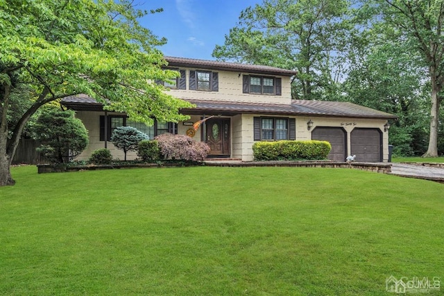 view of front of house with a garage and a front lawn