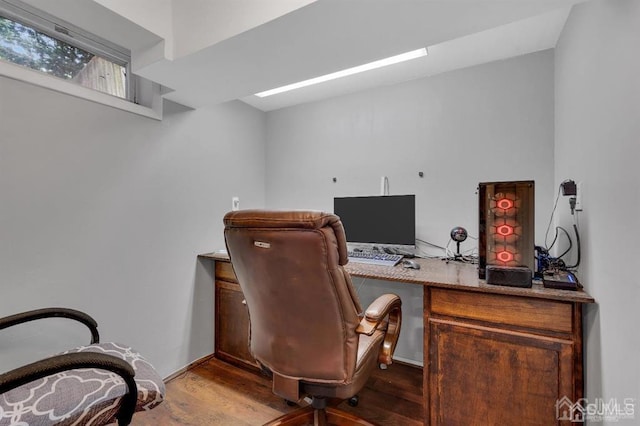 home office with wood-type flooring and built in desk