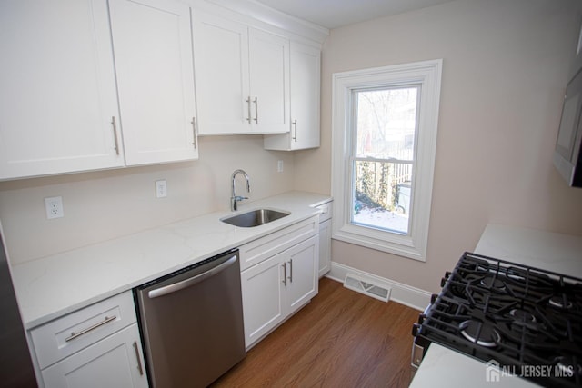 35 Red Bank Rd, Spotswood, NJ 08884 - kitchen featuring dishwasher, black gas range oven, white cabinetry, wood finished floors, and light stone countertops