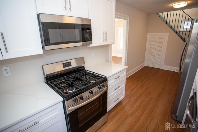 35 Red Bank Rd, Spotswood, NJ 08884 - kitchen with stainless steel appliances, white cabinetry, light stone countertops, and light wood-style flooring