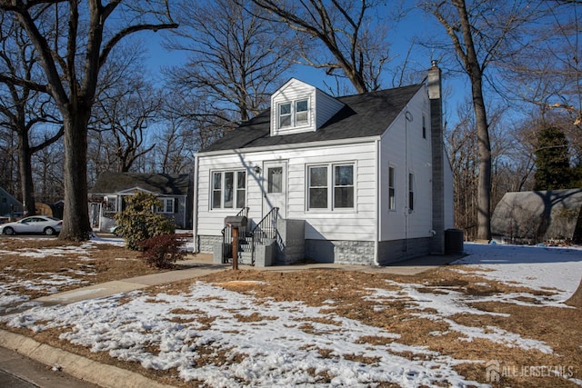 view of front of home with central AC unit and a chimney