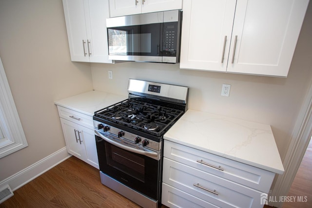 35 Red Bank Rd, Spotswood, NJ 08884 - kitchen featuring appliances with stainless steel finishes, wood finished floors, white cabinets, and light stone counters