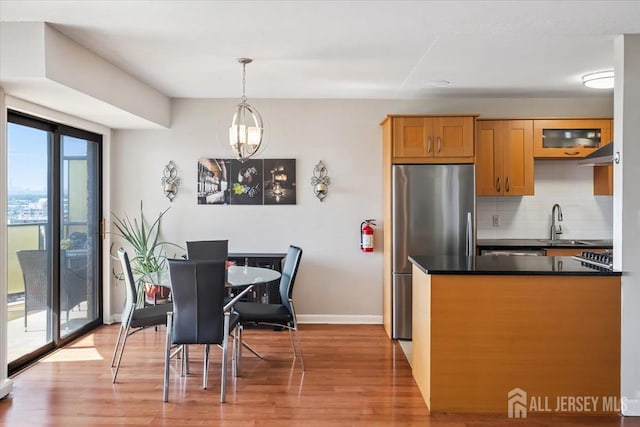 150 Overlook Ave Unit 15E, Hackensack, NJ 07601 - kitchen featuring freestanding refrigerator, dark countertops, backsplash, light wood finished floors, and under cabinet range hood