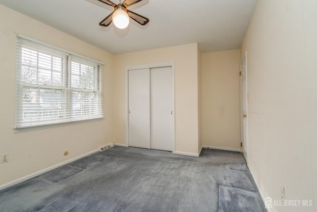 unfurnished bedroom featuring light colored carpet, ceiling fan, and a closet