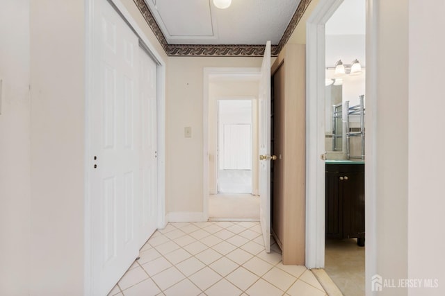 corridor featuring light tile patterned floors and baseboards