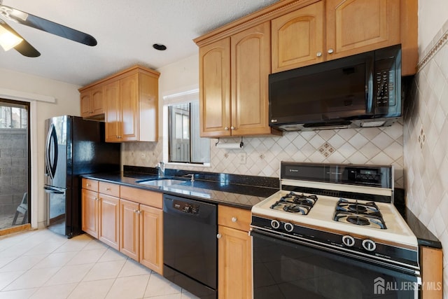 kitchen with black appliances, dark countertops, and a wealth of natural light