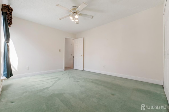 unfurnished room featuring carpet flooring, ceiling fan, and baseboards