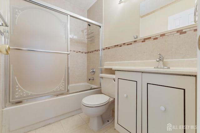 bathroom with vanity, enclosed tub / shower combo, tile walls, toilet, and tile patterned floors