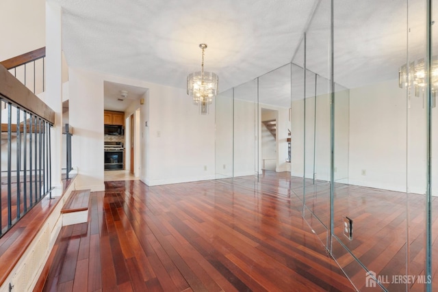 interior space with a fireplace, an inviting chandelier, and hardwood / wood-style flooring