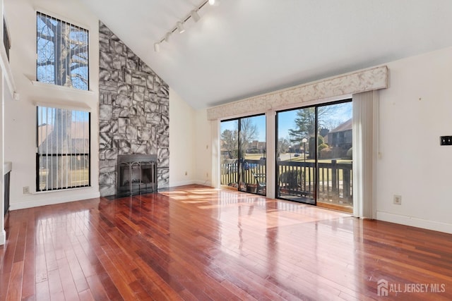 unfurnished living room featuring a fireplace, baseboards, and hardwood / wood-style floors