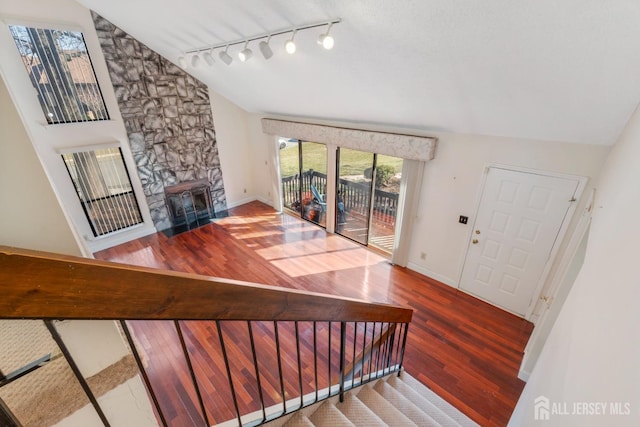 foyer with a fireplace, baseboards, lofted ceiling, and wood finished floors