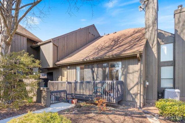 exterior space with central AC unit, a deck, and a chimney