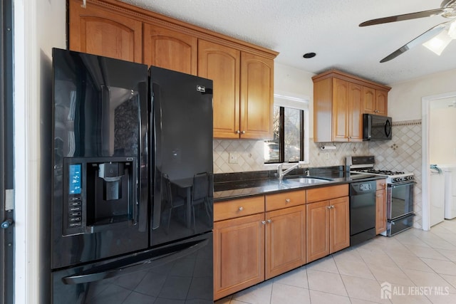 kitchen featuring light tile patterned floors, brown cabinetry, ceiling fan, a sink, and black appliances