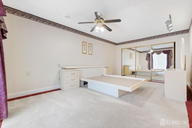 unfurnished bedroom with a ceiling fan, light colored carpet, and baseboards