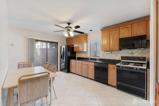 kitchen with black appliances, tasteful backsplash, dark countertops, light tile patterned floors, and ceiling fan