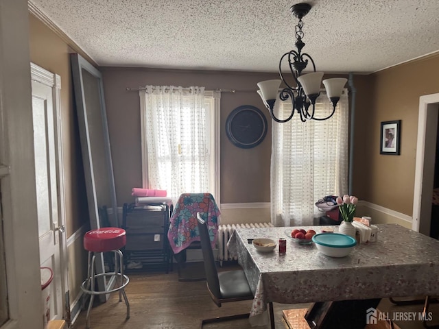 dining area featuring a chandelier, a textured ceiling, and wood finished floors