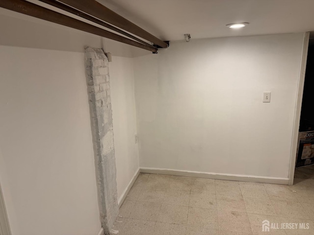 finished below grade area with baseboards and light flooring