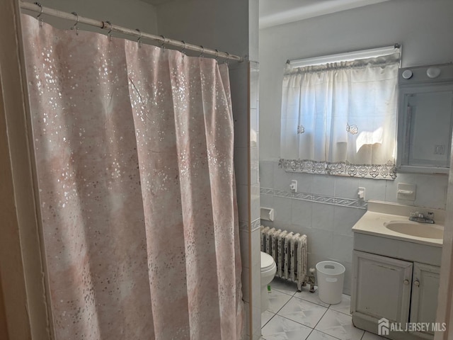 bathroom with radiator heating unit, tile walls, vanity, toilet, and a shower with shower curtain