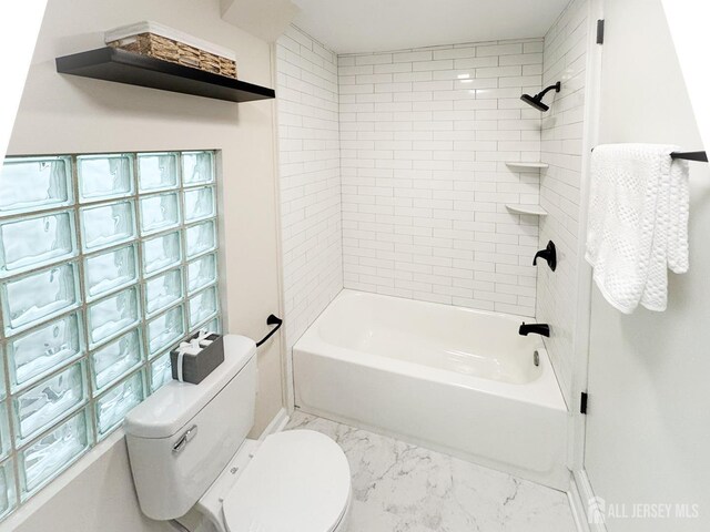 bathroom with toilet and tiled shower / bath