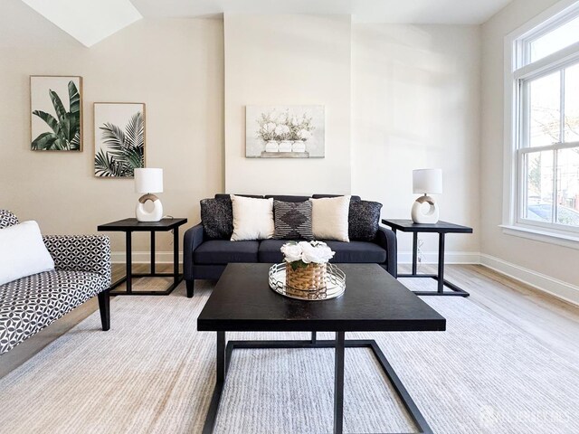 living room with vaulted ceiling and light hardwood / wood-style floors