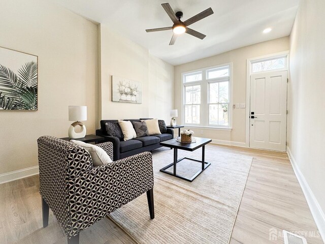 living room featuring light wood-type flooring and ceiling fan