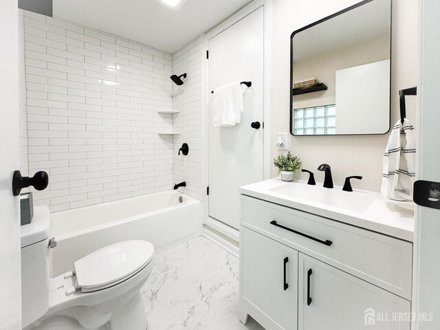 full bathroom with toilet, vanity, and tiled shower / bath