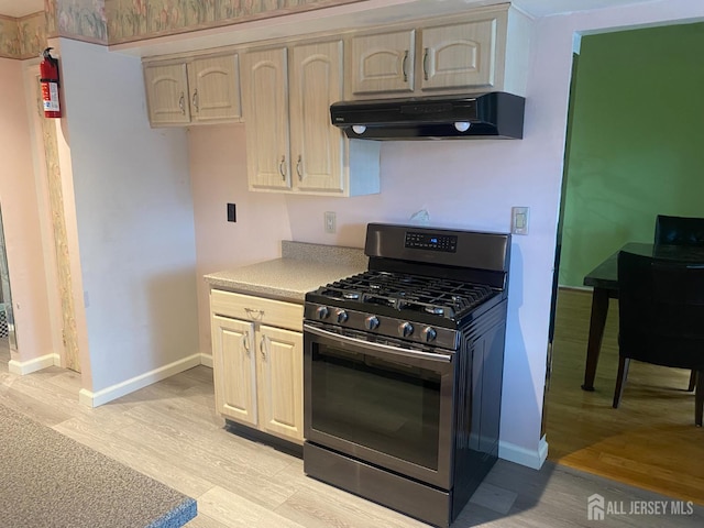 112 Beverly Hill Ter Unit H, Woodbridge Proper, NJ 07095 - kitchen featuring stainless steel range with gas cooktop, under cabinet range hood, light wood finished floors, and light countertops