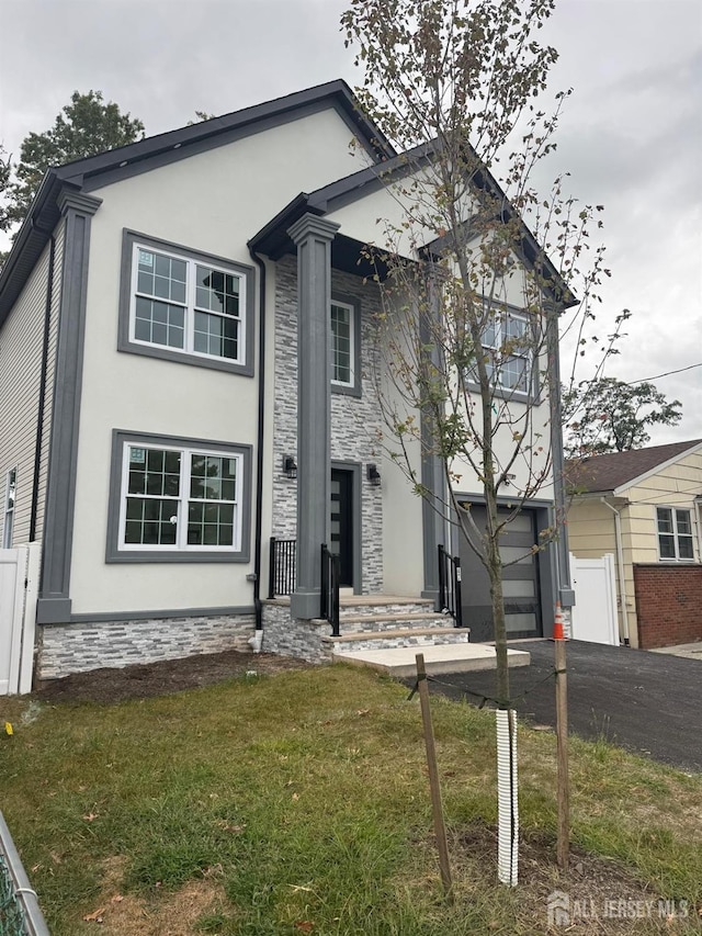 view of front of house featuring a front lawn and a garage