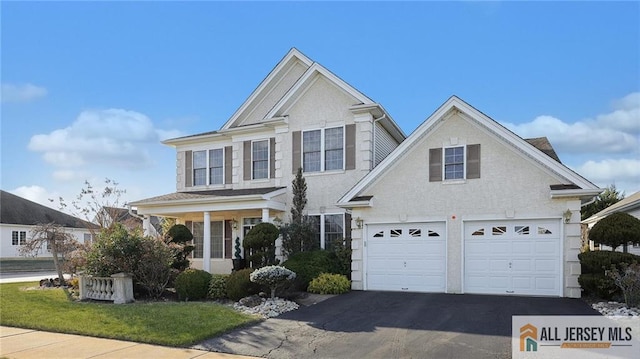 view of front facade with an attached garage, aphalt driveway, and stucco siding