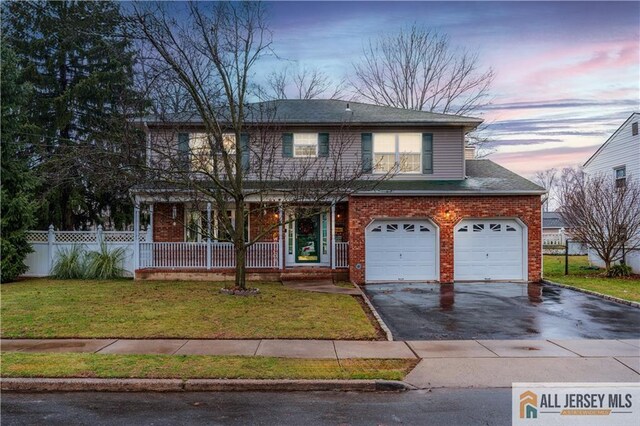 view of front of home with a garage and a yard