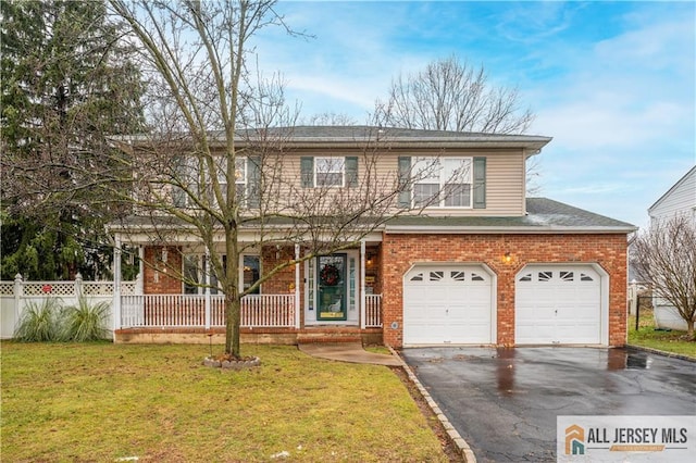 view of front of home featuring a front yard, a porch, and a garage