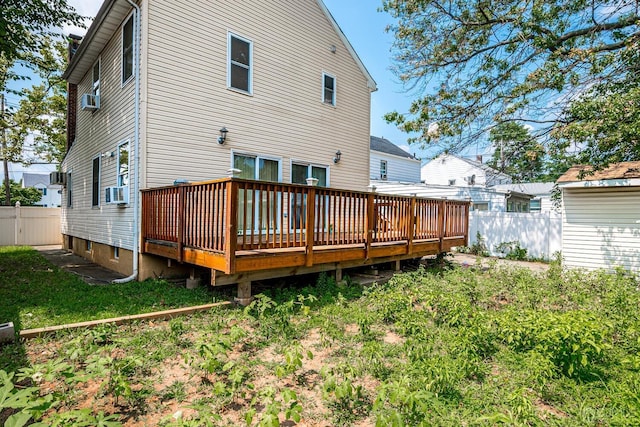 rear view of property with cooling unit, a lawn, and a deck