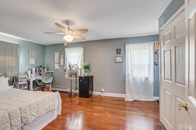 bedroom featuring wood finished floors, baseboards, baseboard heating, and ceiling fan