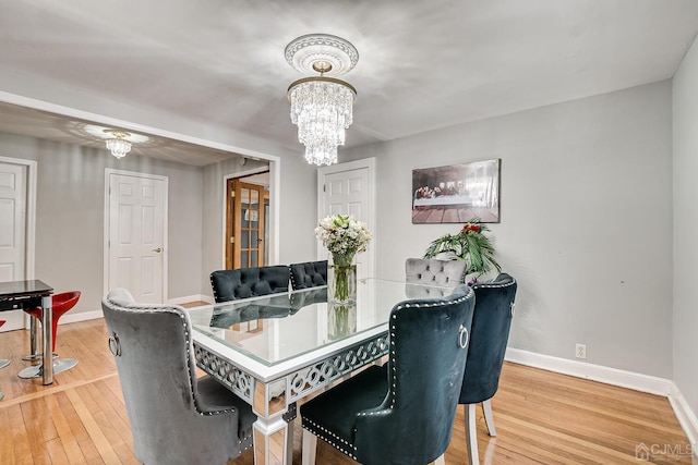 dining room with hardwood / wood-style floors and a notable chandelier