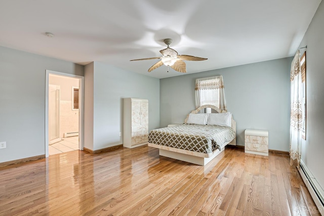 bedroom with baseboards, baseboard heating, and light wood-style flooring