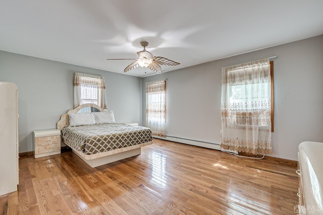 bedroom with a baseboard heating unit, a ceiling fan, and hardwood / wood-style floors