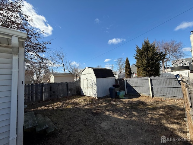 view of yard featuring an outbuilding, a fenced backyard, and a storage shed