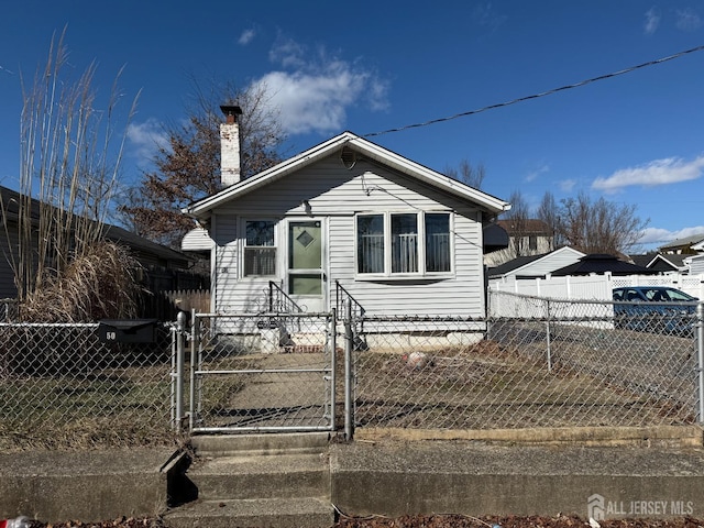 bungalow-style house featuring a fenced front yard, a gate, and a chimney