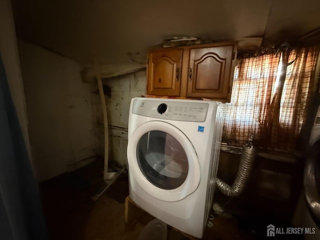 washroom with washer / clothes dryer and cabinet space