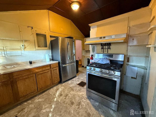 kitchen featuring lofted ceiling, under cabinet range hood, stainless steel appliances, light countertops, and brown cabinetry