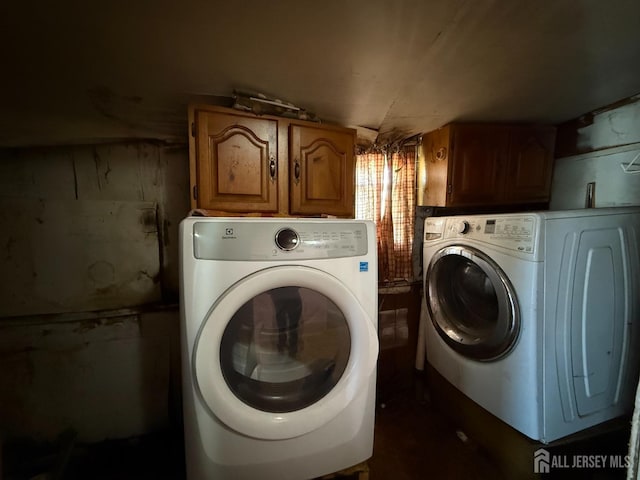 washroom featuring cabinet space and washing machine and clothes dryer