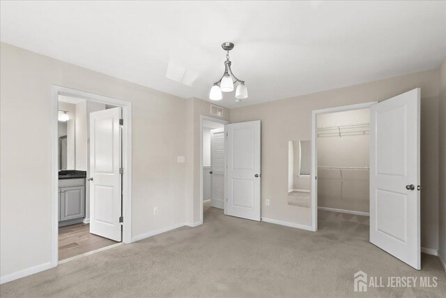 905 Chalmers Ln, Monroe, NJ 08831 - unfurnished bedroom with light carpet, a walk in closet, a chandelier, and ensuite bath