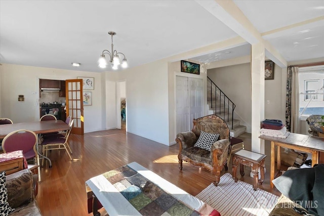 living room with dark wood-type flooring, a notable chandelier, and french doors