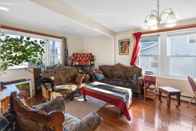 living room featuring cooling unit, an inviting chandelier, and hardwood / wood-style floors